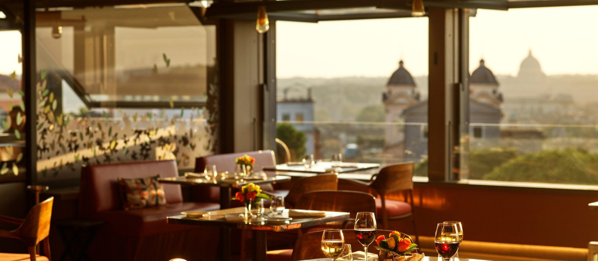 Il Giardino餐厅桌子充满了酒杯和日落在酒店伊甸园，罗马