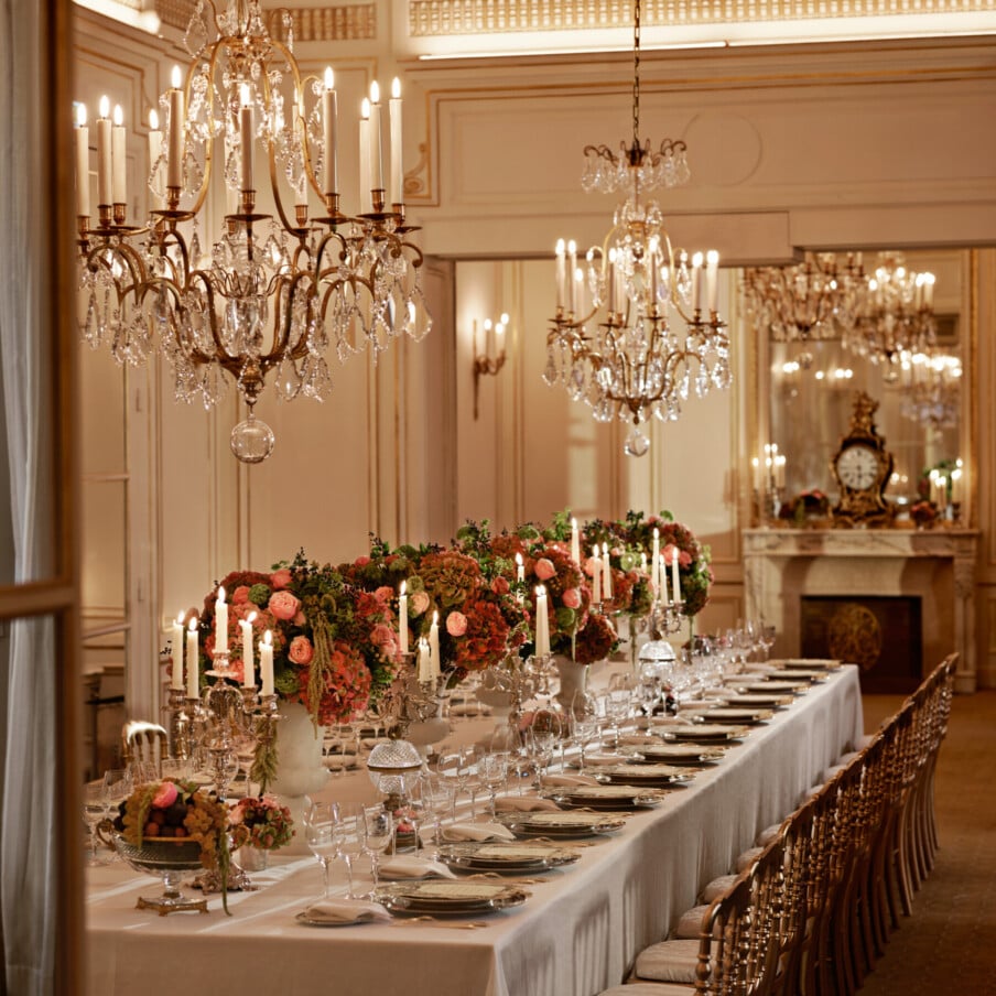 晚餐有金色和白色的餐具，粉红色和绿色的鲜花，水晶吊灯在Le Salon Organza, Hôtel广场Athénée，巴黎-多尔切斯特收藏。bob手机网页版官网