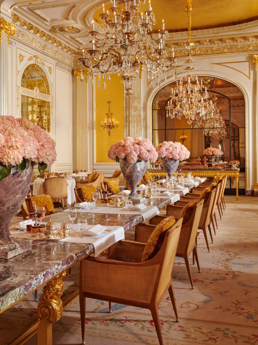 早餐室Hôtel Plaza Athénée，金色天花板和吊灯，大理石大皇家餐桌。